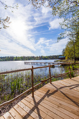 Fototapeta na wymiar Wooden paths along the lake in the spring forest of Karelia 