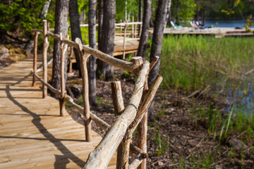 Fototapeta premium Wooden paths along the lake in the spring forest of Karelia 