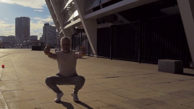 Full length of a senior man doing squats