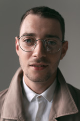 A lonely handsome guy in a raincoat and glasses with different moods