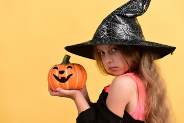 Child in witch costume and jack o lantern