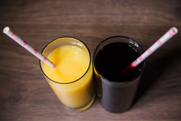 Two fresh glasses of juice with a straw