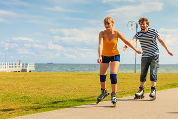 Young couple on roller skates riding outdoors
