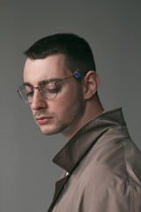 A lonely handsome guy in a raincoat and glasses with different moods