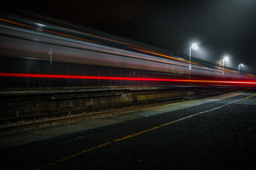 Moving Train at night through station light trails