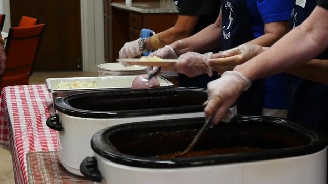 Volunteers serving lunch to the elderly at a church