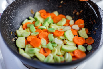 Sliced vegetables in pot. Preparing healthy vegetarian meal.