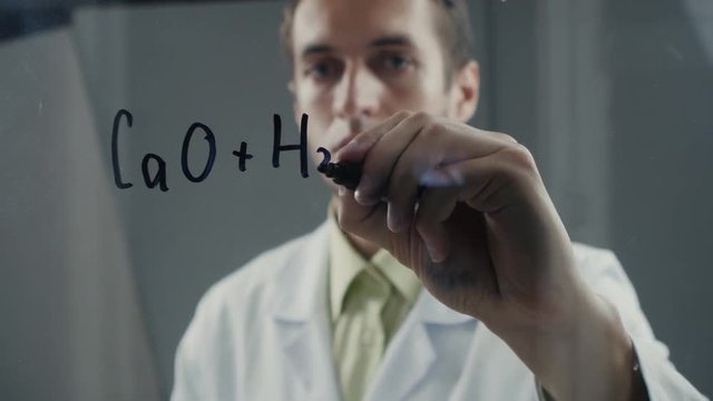 scientist wrote chemical formula on a blackboard.