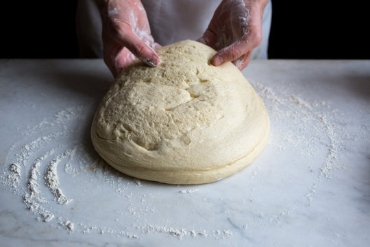 Close-up of man making dough for pizza