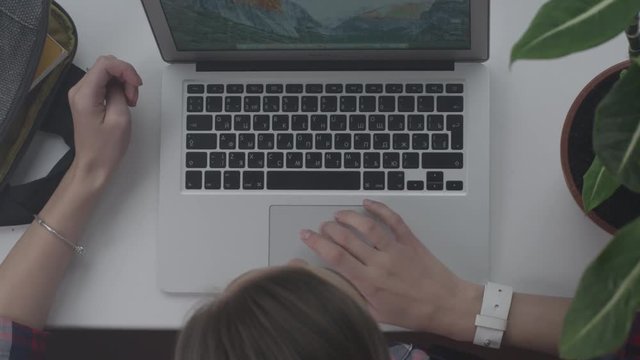 Close up of working hands on laptop on panorama window. Woman working on laptop on the windowsill