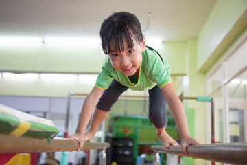 Asian Chinese little girl climbing on parallel bars