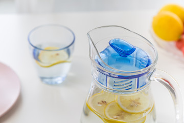 water with fruit, lemon and ice，near the window，bread