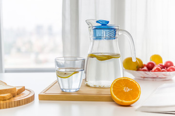 water with fruit, lemon and ice，near the window，bread