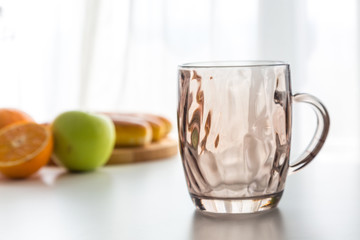 empty glass with fruit near window on the table