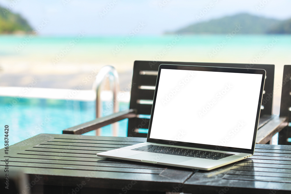 Poster laptop computer showing blank screen on table beauty beach background