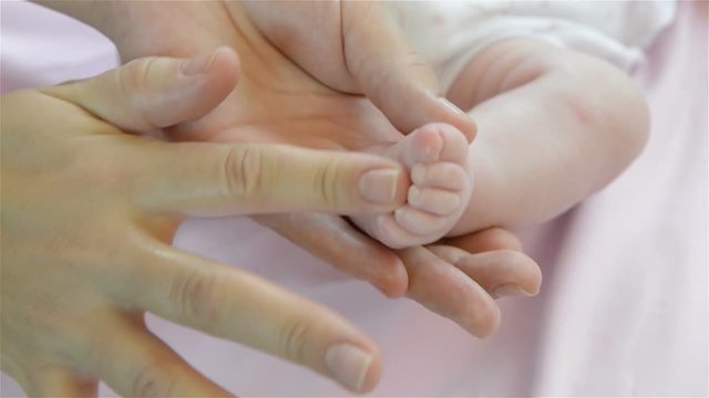 Baby feet in mother hands. Close up of little baby feet in hands of mother. Full HD video