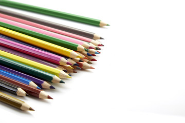 Many different colored pencils on white background
