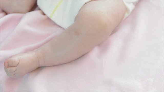 One Leg of little baby girl lying in bed. Full HD video