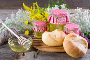 Obraz na płótnie Canvas Honey and wild flowers, Fresh bread on a rustic wooden background