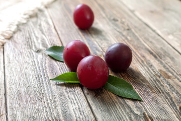 Ripe purple plums on a wooden table
