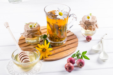 A healthy Cup of  herbal tea, a jar of honey and wild flowers. 