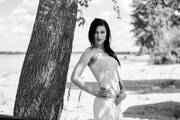 A beautiful tender girl in lacy pajamas relaxes and relaxes on the beach in the morning, surrounded...