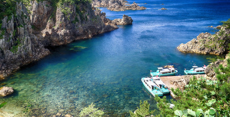 Boats docked at pier at the sea port in Sado island, Japan © eariewboo