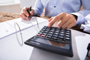 Businessperson Calculating Invoice