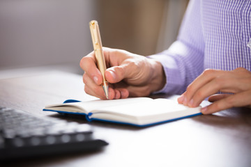 Businessman Writing On Diary