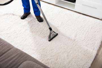 Janitor Cleaning Carpet With Vacuum Cleaner