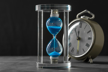 Time is passing. Blue hourglass close up