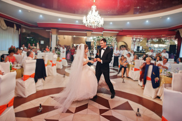 The first dance of newly married couple at their wedding party in restaurant.