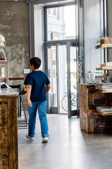 Kid in a hipster looking coffee shop open for the day with a retro design.