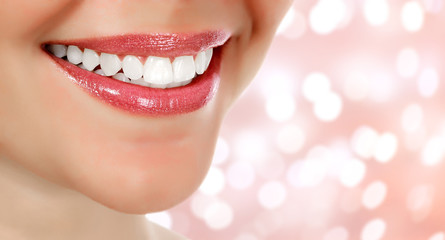 Fototapeta premium Picture of woman's smile against an abstract background with blurred lights