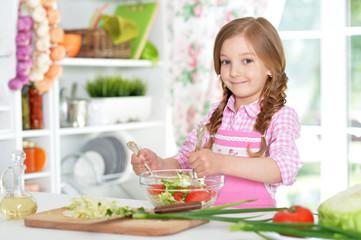 little girl preparing vegetable salad