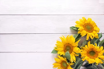 Papier Peint photo Tournesol Background with a bouquet of yellow sunflowers on  white painted wooden planks. Space for text.
