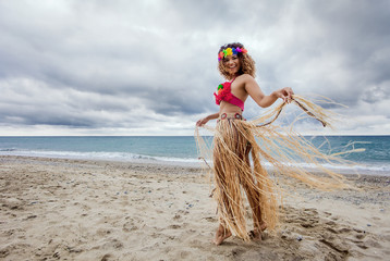 Happy and cheerful hawaiian woman portrait dancing on the beach