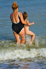 Grandmother and granddaughter bathe in the open sea. July 2017, Odessa, Ukraine.