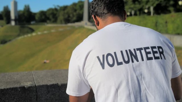 Dolly shot of a kind male volunteer sitting outdoors