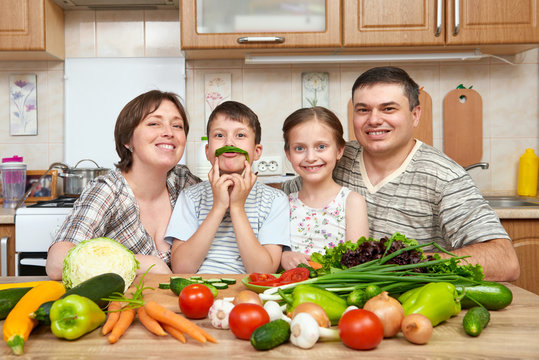 family portrait in kitchen interior at home, fresh fruits and vegetables, healthy food concept, woman, man and children cooking and having fun