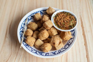 Fried tofu by soybean and Suace with syrup, peanut and chilli Thai food. Food on the wood background 