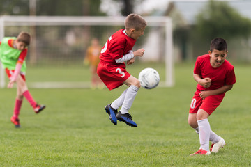 Fototapeta premium Kids soccer football - children players match on soccer field