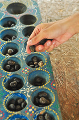 congkak, congklak or dhakon, Traditional game with lots of holes and using seeds