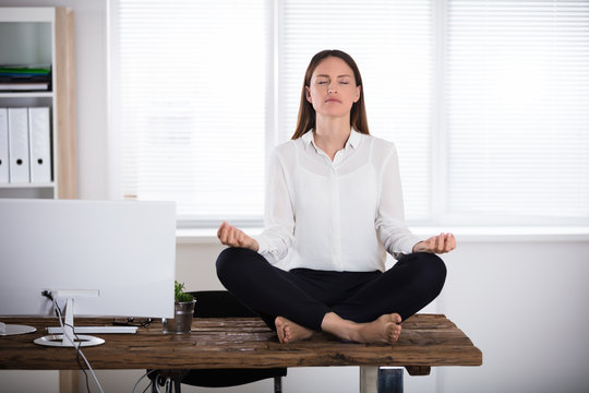 Young Businesswoman Meditating In Office