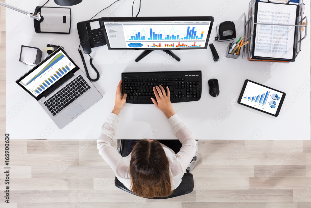 Poster high angle view of a businesswoman analyzing graph in office