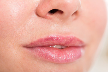 Naklejka premium Close-up of woman's lips with natural lipstick make up. macro lipgloss make-up