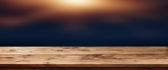 Dark background with lighted wooden table