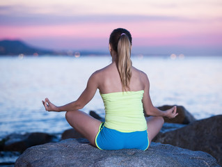 Fototapeta na wymiar Positive sportwoman meditating in yoga padmasana