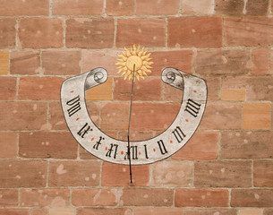 Sun clock painted on the brick wall