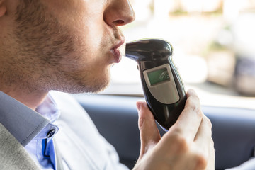 Man Sitting Inside Car Taking Alcohol Test